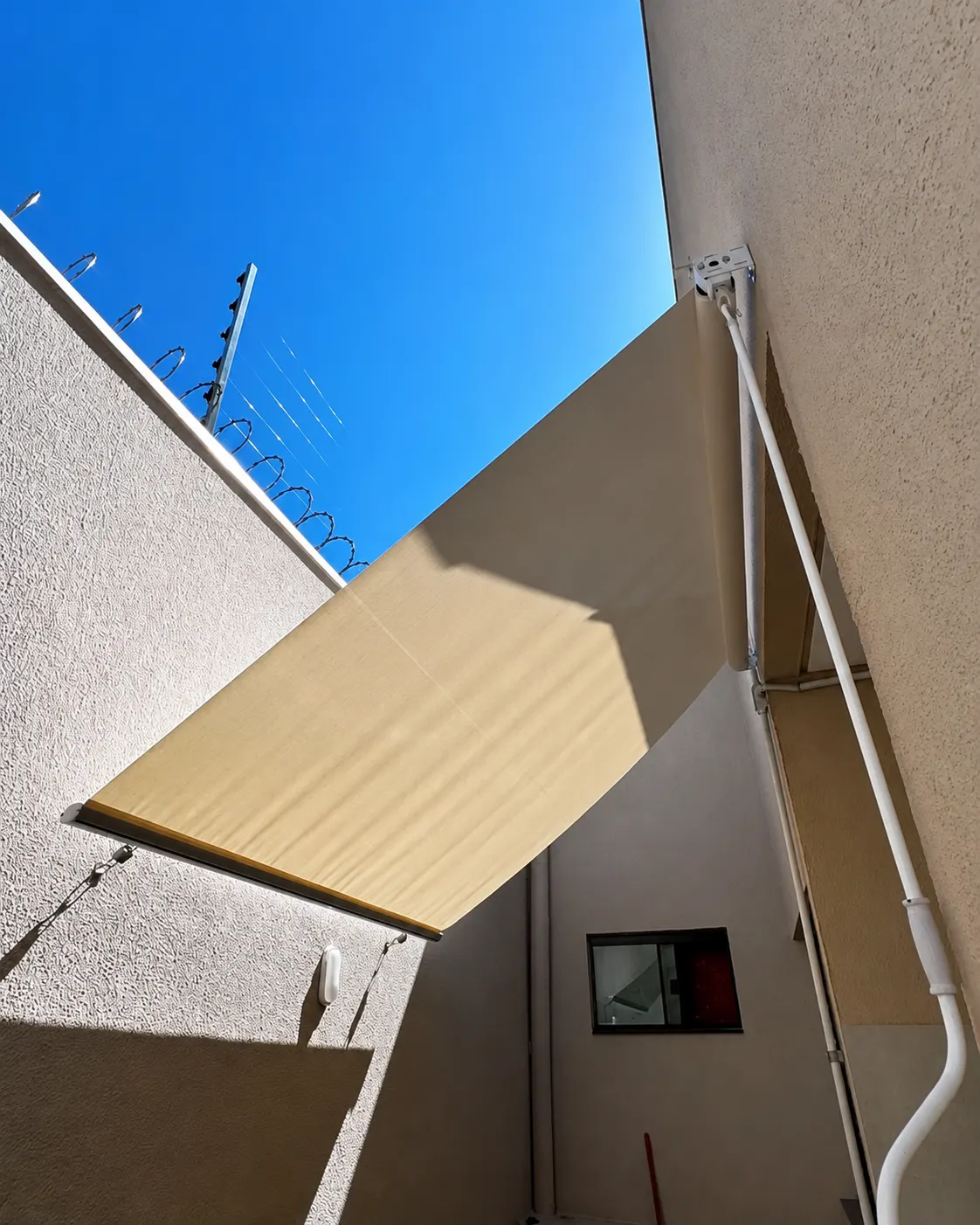 Toldo retrátil articulado instalado em área externa residencial
